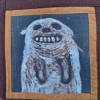 12x12' inkodye and embroidery 2019                           I have used this  image of a laughing dog in several pieces: a painting, a woodblock print, and this one, an embroidery on printed textile.  It cheers me up!